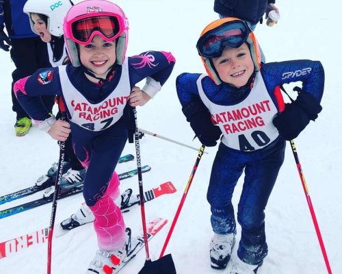 Two young girls in ski racing equipment as part of the Development Ski Race Program at Catamount Ski Resort